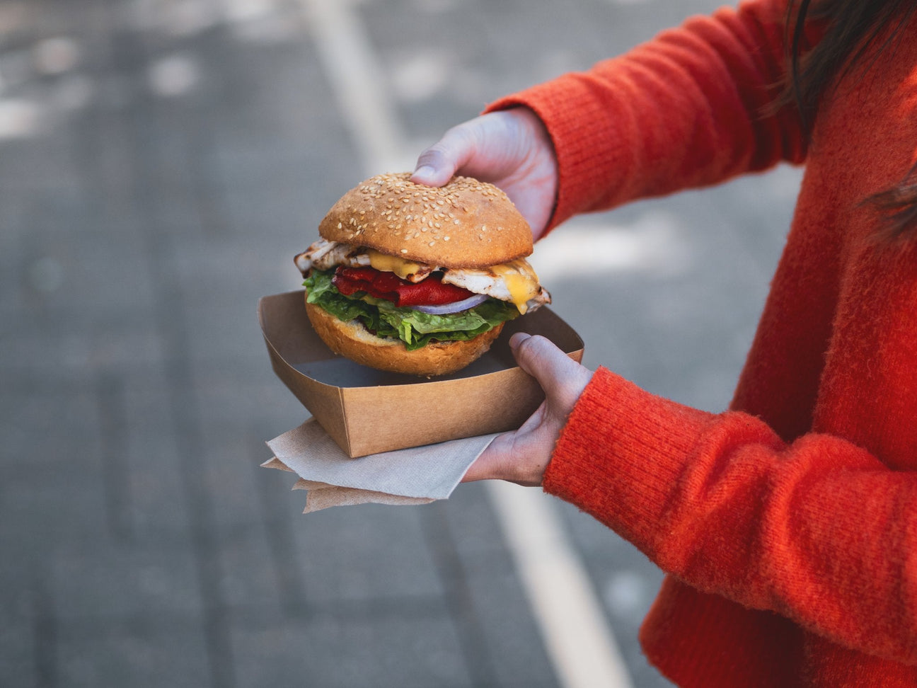 disposable kraft food tray containing a burger and sustainable napkin