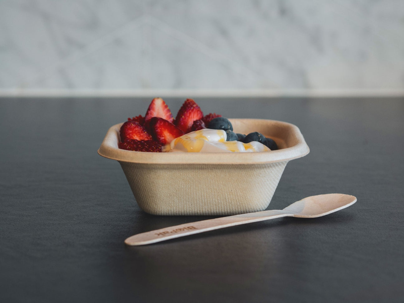 small square takeaway container and wooden spoon