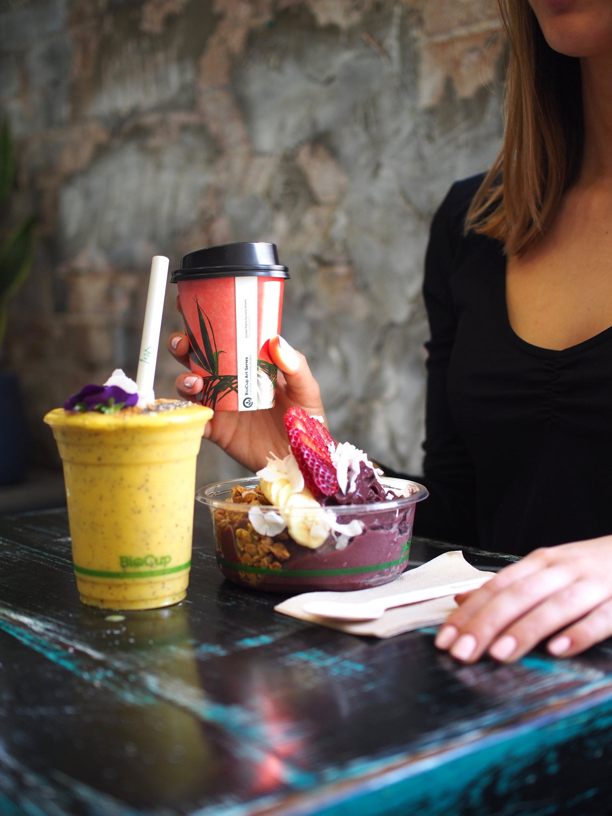 takeaway coffee cup and compostable clear cold cup with snack pot acai bowl in a cafe