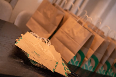 takeaway paper kraft bags with twisted handle on a table