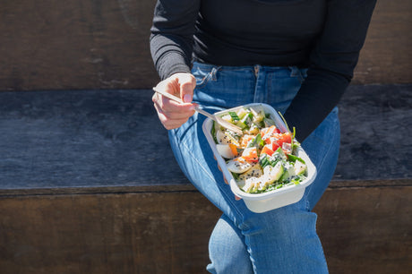 rectangular takeaway bowl and wooden fork serving a potato salad