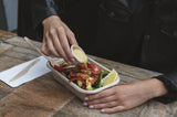 disposable sauce pots and bagasse takeaway container containing a serving of chicken greek salad