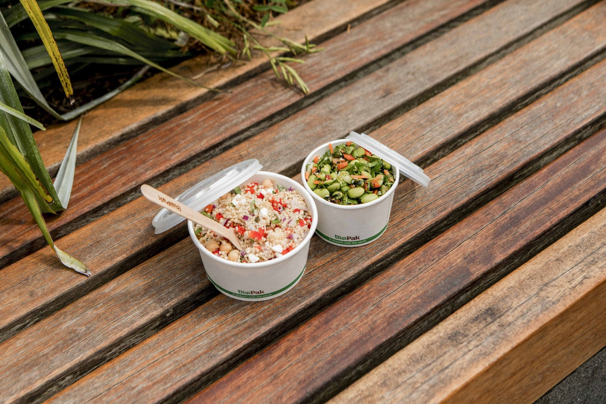 compostable paper bowls with pla lids and wooden cutlery to serve a takeout couscous and edamame bean salad